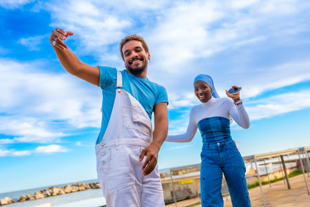 Urban people dancing and looking at camera next to the sea with blue skyの写真素材