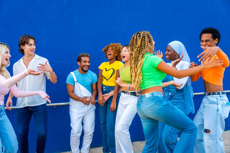 Group of young people dancing together outdoors at a multicultural partyの写真素材