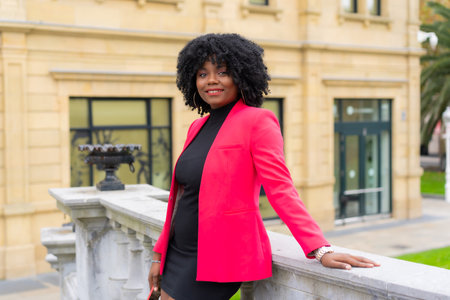 Portrait of an african businesswoman in vivid colorful clothes posing in a public parkの写真素材