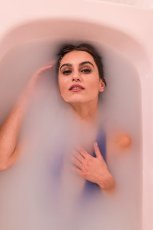 Artistic portrait of the top view of a beauty woman in a milk bathの写真素材