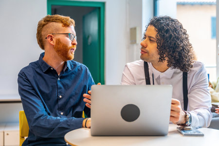 Frontal portrait of two colleagues working together using laptop in a coworkingの写真素材