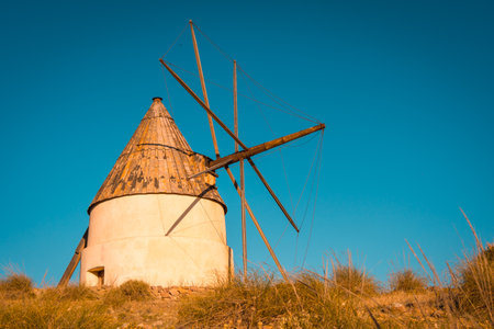 Colorful photo of an ancient windmill during sunset in Cabo de Gata, Spainの写真素材
