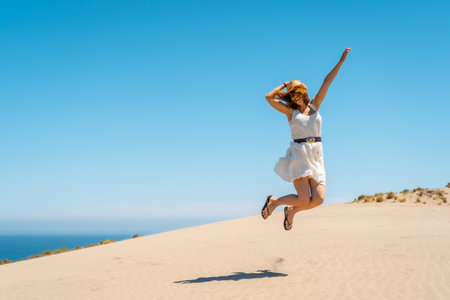 Happy woman jumping in a view point with sea views in Cabo de Gata, Spainの写真素材