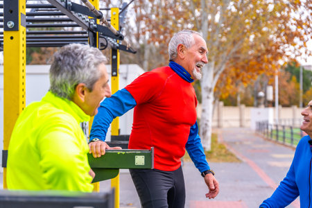 Retired group of mature men in an outdoor sports ground chatting relaxedの写真素材