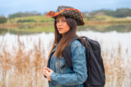 Portrait of a beauty adventurer with denim clothes, hat and bag traveling aloneの写真素材
