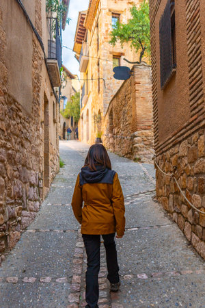 A woman walking through the streets of the Pyrenean village of Alquezar, medieval town of Huesca, Spainの写真素材