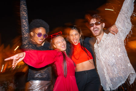Night photo with flash and motion of multi-ethnic friends having fun during city night