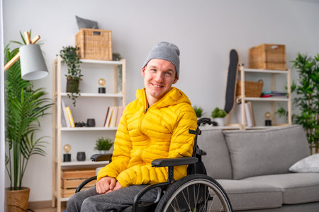 Portrait of cheerful disabled man in wheelchair smiling at camera in the living room at homeの写真素材