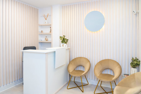 Minimalist and chic interior of a reception of beautician clinic with counter and chairsの写真素材