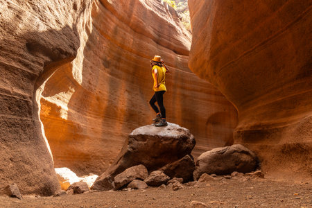 A woman in a yellow t-shirt in the limestone canyon Barranco de las Vacas in Gran Canaria, Canary Islandsの写真素材