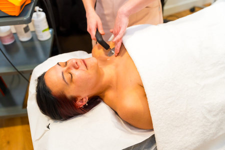 Unrecognizable therapist using Indiba machine technology to treat pain in the shoulder of a patient
