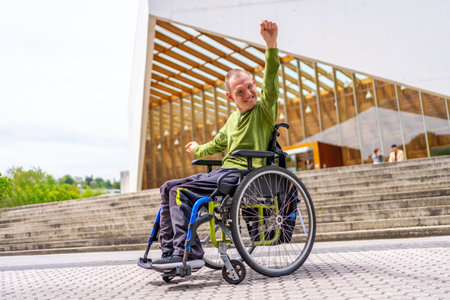 Disabled man in wheelchair proud celebrating he achieved to go to the universityの写真素材
