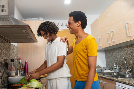 Multi-ethnic gay male couple preparing healthy salad standing in the kitchen at home