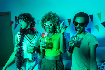 Multi-ethnic young students dancing and drinking alcohol during night party at home