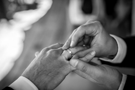 A man and woman are getting married and the man is putting a ring on the woman's fingerの写真素材
