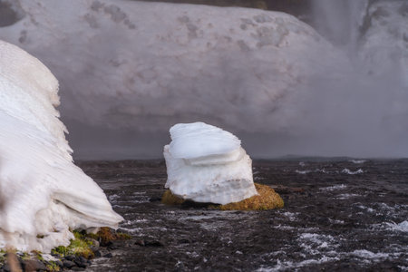 Detail of ice on the Seljalandsfoss waterfall with snow in Iceland