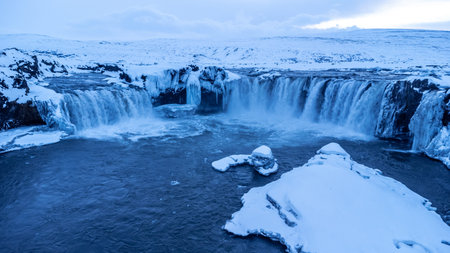 Amazing scenery of frozen Godafoss waterfall at sunset in winter, Iceland.