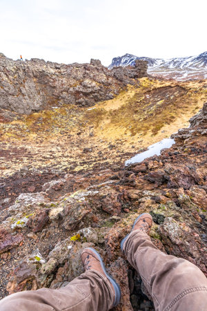 Point of view of a man sitting in the crater of Saxholl Crater volcano in winter in Iceland, Snaefellsnes Peninsulaの写真素材