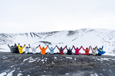 A group of adventurous friends on the Hverfjall volcano in Myvatn Nature Park, Iceland. Concept of an adventure holiday with friends enjoying a beautiful country in northern Europeの写真素材