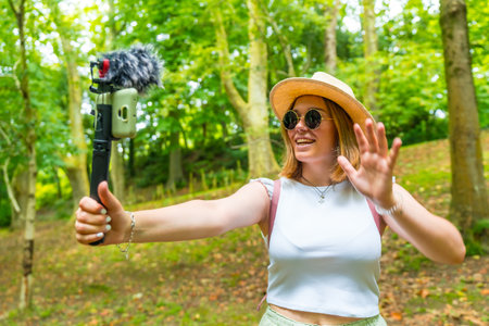 Side view of a caucasian young stylish woman hiker recording vlogの写真素材