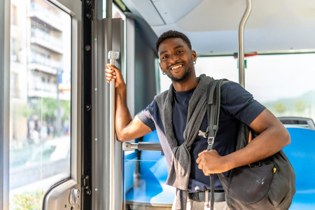 Confident handsome african student on the bus on the way to universityの写真素材