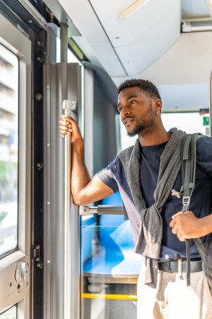 Vertical photo of a casual african businessman on the public bus on the way to work in the morningの写真素材
