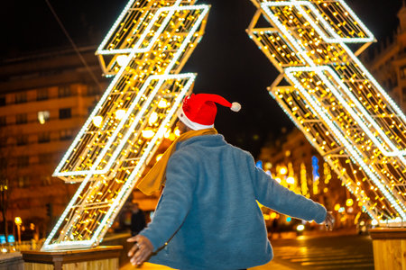 African man with Santa hat expressing happiness during a Christmas night in the cityの写真素材