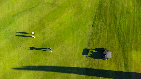 Aerial top view of three people on a green luxury gold courseの写真素材