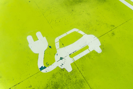 A green parking lot with a car charging station