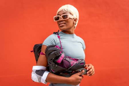 Cool futuristic woman with inline skates and protective gear against red background