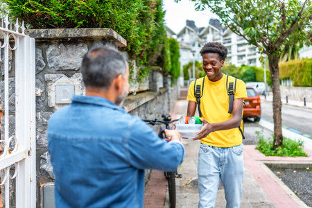 Delivery man delivering food and beverages to a client at homeの写真素材