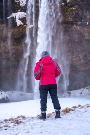Portrait of a woman in the cold Icelandic winter at Seljalandsfoss waterfallの写真素材