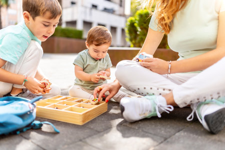 Cropped photo of a part of a woman playing with her sons in an urban parkの写真素材