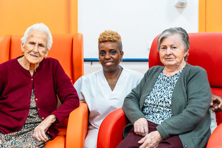 African caregiver and two senior women in the hall of geriatricsの写真素材