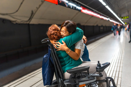 Disabled woman and friend reunited on the metro platformの写真素材