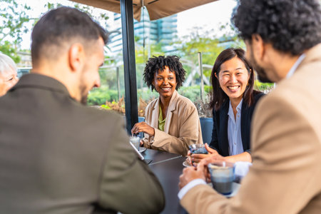 Happy and relaxed multi-ethnic business people talking in a cafe during work breakの写真素材