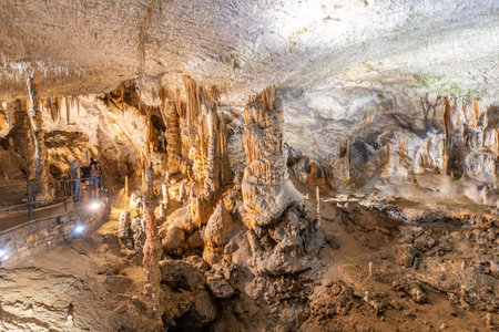 Tourists admiring the magnificent formations of stalactites and stalagmites inside postojna cave, a popular tourist attraction in Sloveniaの写真素材