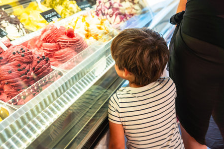 Child looking at colorful ice cream flavors in a shop refrigerated display, enjoying summer holidays in Piran, Sloveniaの写真素材