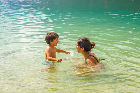 Mother and son enjoying refreshing swim in lake bohinj's crystal clear water during summer holidayの写真素材