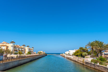 Calm canal flowing to the sea between residential buildings in La Manga del Mar Menor, a touristic coastal strip in Murcia, Spainの写真素材