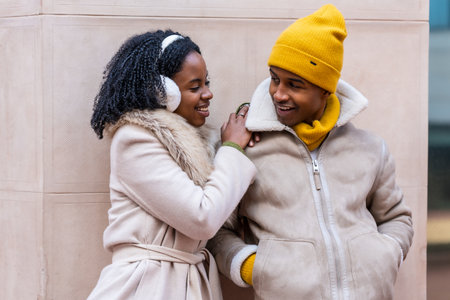 Two friends enjoying a winter day in the city, sharing a moment of complicity and affectionの写真素材