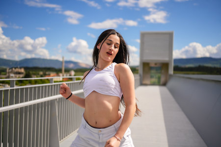 Close-up of a cool caucasian woman in sportive clothes dancing urban style danceの写真素材