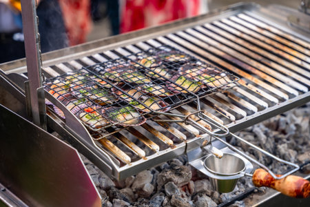 Fresh vegetables grilling on an outdoor barbecue, showcasing vibrant colors and delicious aromas,...