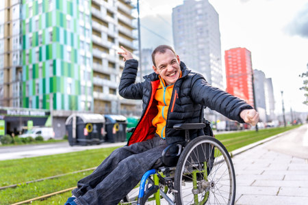 Portrait of a cheerful disabled young man enjoying a day out in the city, celebrating his mobility and independenceの写真素材