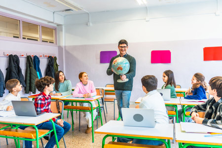 Geography teacher engaging students while holding a globe, fostering learning and understanding in a vibrant classroom environmentの写真素材