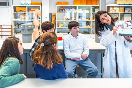 Science teacher engaging high school students with an anatomical model during an interactive biology lesson in the classroomの写真素材