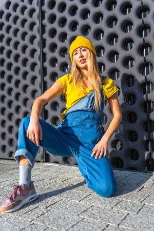 Young blonde woman wearing casual clothes dancing urban dance outdoors near a modern building facadeの写真素材