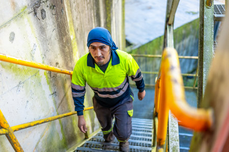 Top view of a man worker walking up stairs outside a recycling plant buildingの写真素材