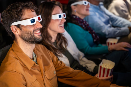 Group of friends enjoying a 3d movie at the cinema, wearing 3d glasses and eating popcornの写真素材