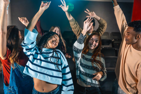 Friends are dancing and having fun at a movie disco event inside a cinema, enjoying music and the company of each otherの写真素材